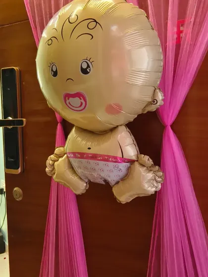 A cute baby-shaped foil balloon as part of a welcome home door decoration, adding a playful and adorable touch to the celebration.