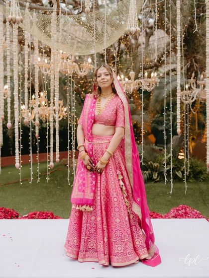 A full-length view showing how the natural makeup look works beautifully with the bright and festive wedding decor. She looks comfortable, happy, and radiant.