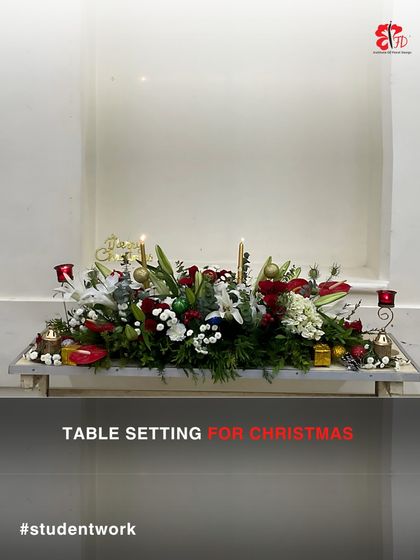 A magical Christmas table setting created by one of our students. This long and low centerpiece incorporates candles, ornaments, lilies, and roses, perfect for a festive holiday dinner.