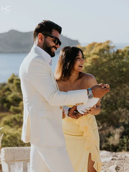 My clothing is designed for life’s best moments. Here, a client celebrates in a bespoke white suit, perfectly tailored for a special occasion with a backdrop of sun and sea.