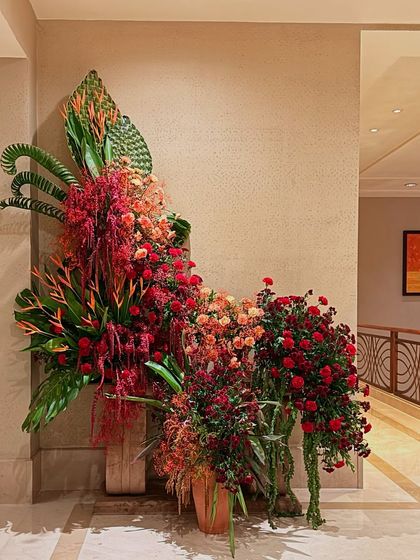 Another angle of the fiery red and orange installation, showing its graceful curves and the interplay of different floral textures.