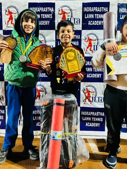 Young winners from the ILTA prize money tournament in Pitampura. They are holding their trophies, medals, and other prizes.