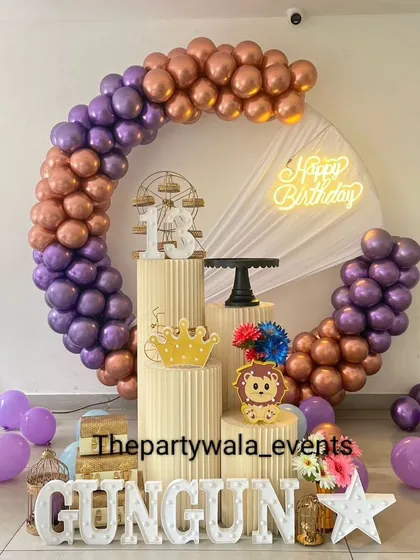 A beautiful ring decoration with purple and rose gold balloons. The setup is perfect for a teenager's birthday, with a light-up number "13" and elegant props.