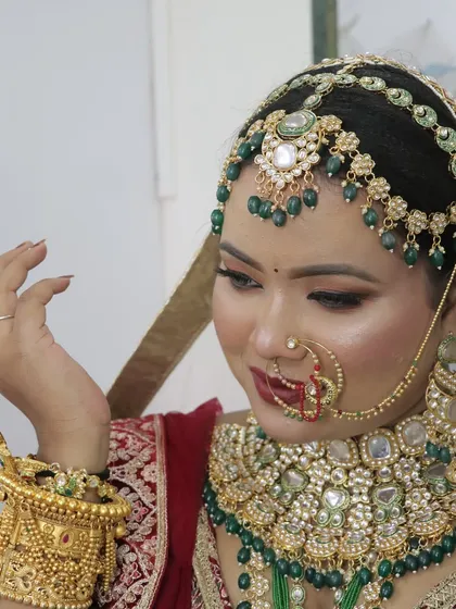 A delicate pose highlighting the intricate hand jewellery and the rich embroidery of her lehenga.