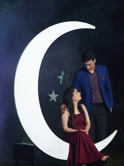"You are my sun, my moon, and all my stars." This dreamy pre-wedding photo with a moon prop creates a magical and whimsical atmosphere.