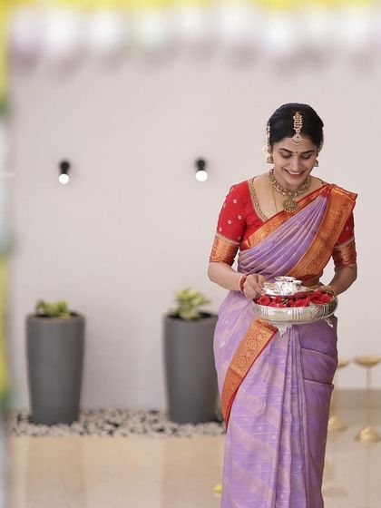 Another shot of the bride during her housewarming ceremony, her smile as bright as her outfit.