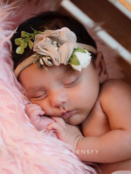 A close-up of a sleeping newborn, showing their perfect, delicate features. These are the tiny details you'll want to remember as they grow so quickly.