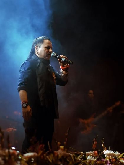 A moody, atmospheric shot of Kailash Kher on stage, surrounded by smoke. This frame captures the soulful and introspective side of his musical performance.