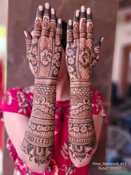 A gorgeous full-arm bridal design with a mix of floral and geometric patterns. The palms feature the couple's initials, 'JP' and 'DS', in a traditional style.