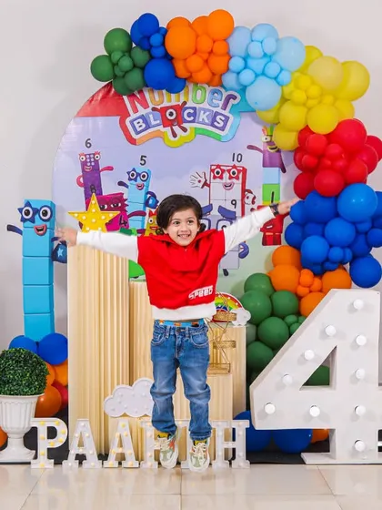 Pure joy in mid-air! We love capturing the energy of a party, like this little one jumping for joy at his action-packed Numberblocks themed 4th birthday. This setup included character cutouts, a colorful balloon arch, and a large light-up number four.