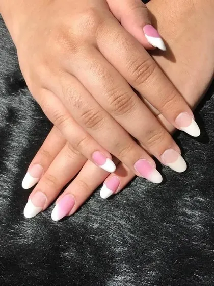 A student practicing acrylic extensions for French variations. We encourage practice on models to simulate a real salon environment and perfect the application.