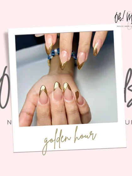 Golden hour, but make it chrome. This design features a sharp, V-shaped French tip created with a stunning, reflective gold chrome polish.