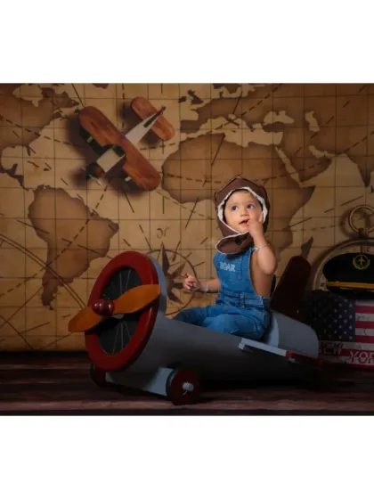 A curious pilot looking out from his plane. The combination of props creates a complete story for your child's portrait.