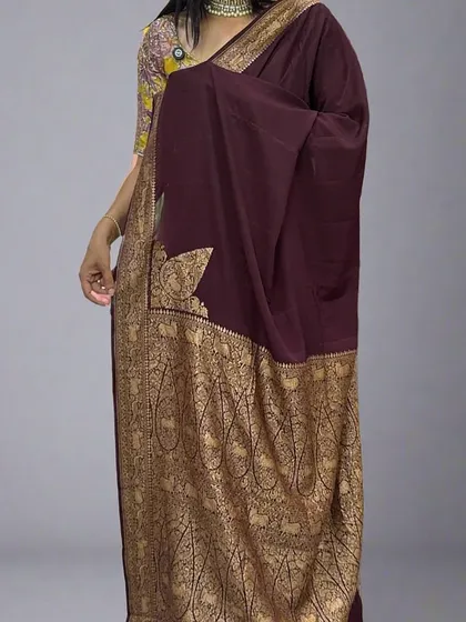 A full view of our restocked dark brown Banarasi saree. The rich, deep color paired with the golden paisley border creates a timeless and regal look. It’s shown here with a contrasting floral blouse.