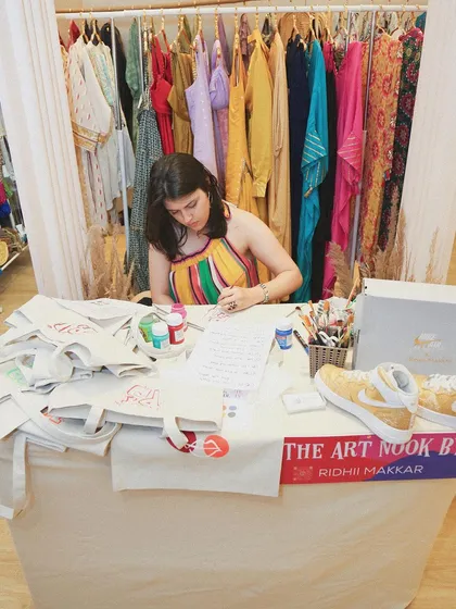 A wider shot of my setup at the Project Tete-a-Tete event. I was busy all day painting custom designs on tote bags for shoppers, creating unique keepsakes for them.