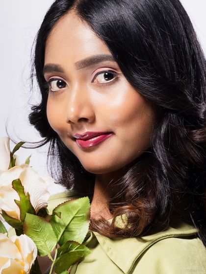 A close-up of a model holding roses, with a soft and gentle expression.