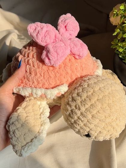 A close-up of our pink butterfly turtle. The chunky yarn gives it a wonderfully soft and substantial feel.
