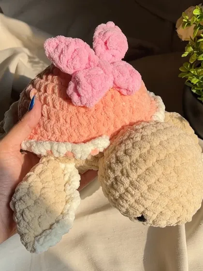 A close-up of our pink butterfly turtle. The chunky yarn gives it a wonderfully soft and substantial feel.