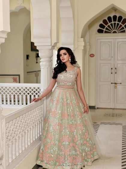 Blooming with summer hues. This pastel green and pink floral embroidered lehenga is a fresh and beautiful choice for a bridesmaid. The one-shoulder cape adds a modern, stylish touch.