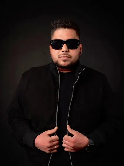 A classic, confident pose against a black background. My style is bold and direct, just like my music.