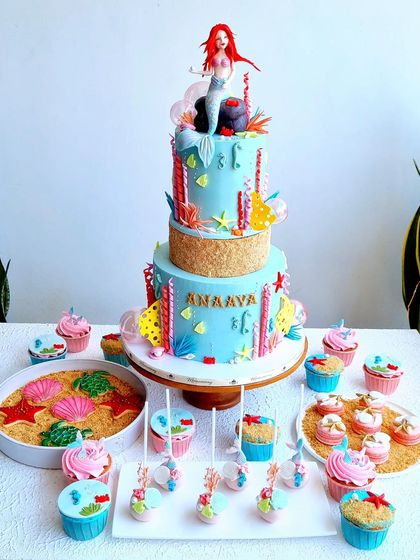 The complete Ariel-themed dessert table, with the cake, cupcakes, macarons, cookies, and other treats.
