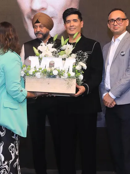 A specially curated gift hamper with white blooms for a design school event, being presented to the renowned designer Manish Malhotra.