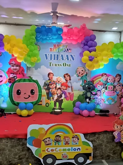 A vibrant and colorful Cocomelon theme for a first birthday party. This setup is packed with characters from the show, a rainbow balloon arch, and a custom backdrop to create a fun and cheerful atmosphere for the little ones.