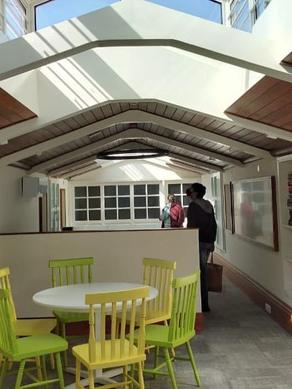 The same attic space seen from another perspective, highlighting the custom shelving and bright, airy atmosphere that encourages collaboration.