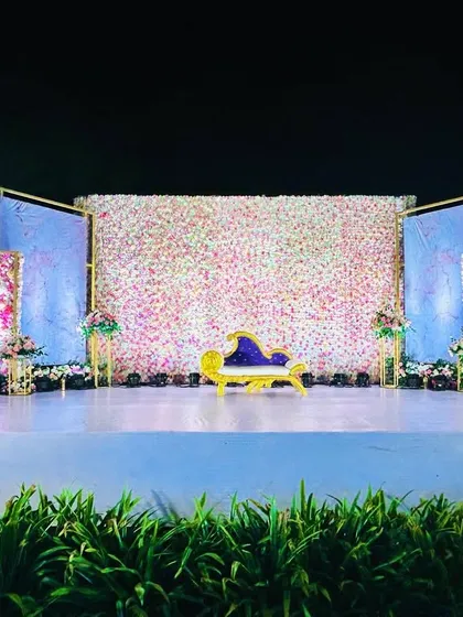 Another perspective of the floral wall stage, showcasing the careful placement of flowers and the elegant, curved divan.