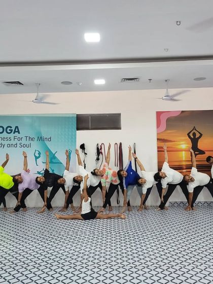A wide shot of our group practicing Trikonasana (Triangle Pose) together. The alignment and synchronicity are beautiful to see.