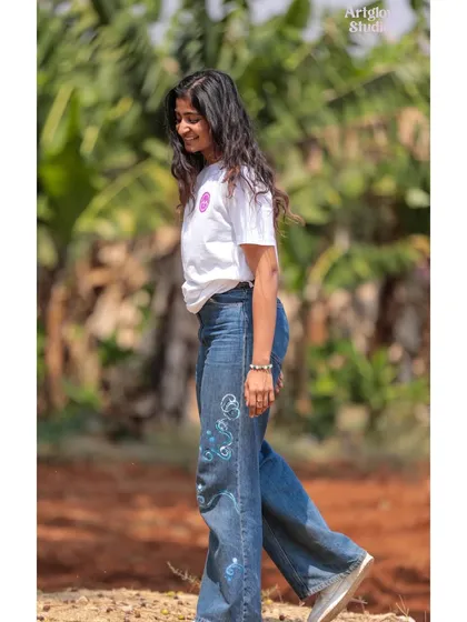 A side view of my cosmic-themed jeans. The swirling blue patterns wrap around the leg, creating a dynamic and eye-catching design.