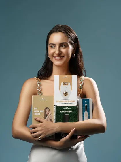 A lifestyle shot for a personal grooming brand. The model holds a variety of products, showcasing the entire range in a single, friendly, and approachable image that feels authentic and trustworthy.