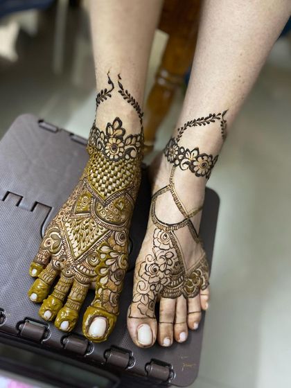 A unique bridal foot design, with one foot heavily detailed and the other featuring a lighter, complementary pattern.