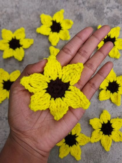 Holding a sunflower applique to show its size and detail. The possibilities for these are endless!