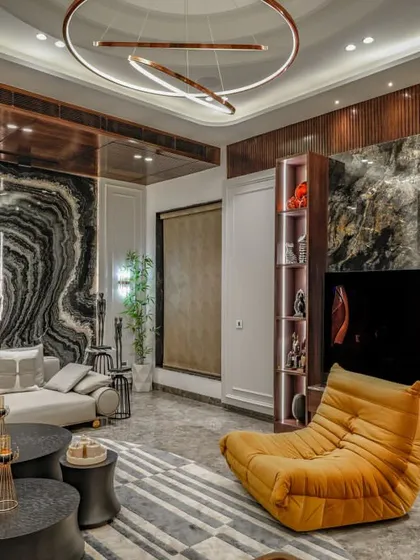 Another perspective of the same living room, highlighting the concentric circle ceiling design and the dramatic marble feature wall.