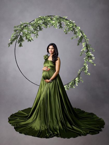 A classic portrait in a satin olive green gown, with a leafy hoop prop creating a beautiful frame.