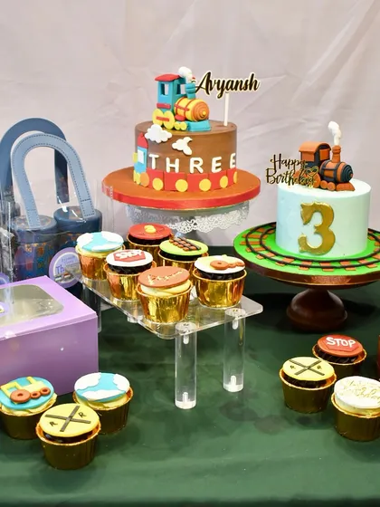I love creating entire dessert tables that tell a story. For this train-themed third birthday, I designed two custom cakes, matching cupcakes with fondant toppers, and personalized gift hampers to create a cohesive and memorable celebration for Avyansh.