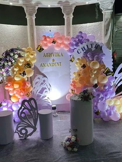 Another take on the butterfly theme, this time with large, freestanding butterfly wing props for the perfect photo opportunity. The pastel orange and purple balloons add a soft, dreamy touch.
