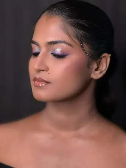 The vibrant purple and silver glitter eyeshadow is blended to perfection. We teach our students to be bold with color and precise with their application.