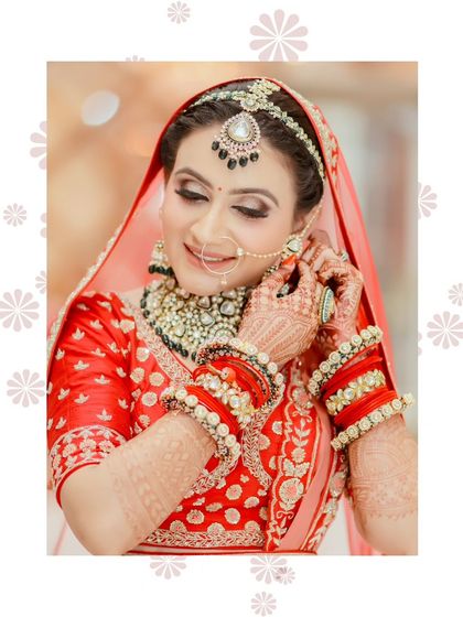 The bride adjusting her nose ring, a classic candid moment. The makeup remains flawless even with movement.
