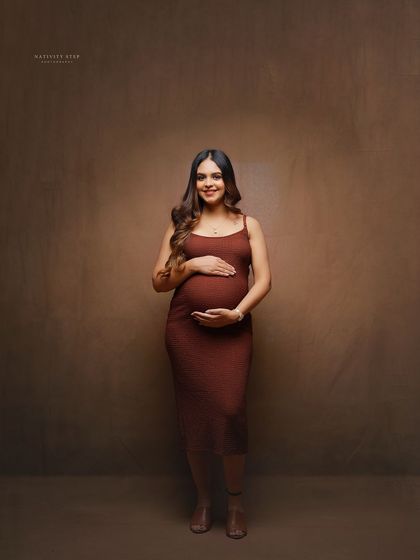 A full-length solo portrait against a warm, neutral backdrop. This shows how we can create a professional studio look even during a shoot at your place.