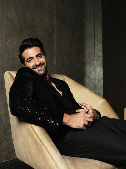 A smiling portrait from the same set, capturing a moment of genuine warmth and charisma.