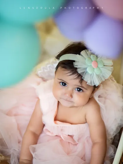 A beautiful close-up portrait from the hot air balloon shoot. The soft colors of the headband and balloons complement her sweet expression perfectly.