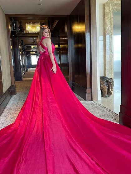 The back view of the pink satin trail gown, showcasing its impressive length and the open-back design.