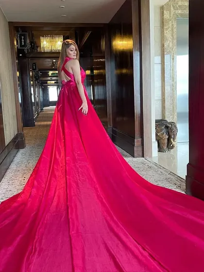 The back view of the pink satin trail gown, showcasing its impressive length and the open-back design.