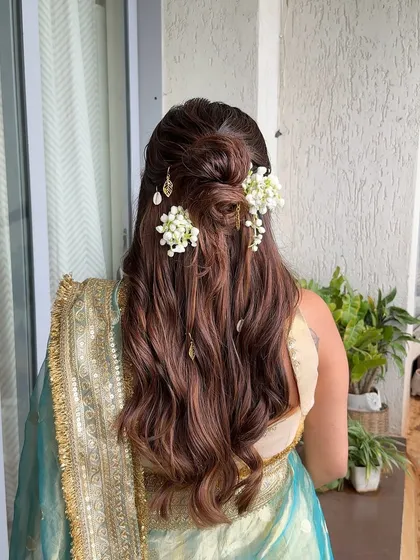 For this baby shower, I created a half-up style with a messy floral bun and soft waves, accented with delicate golden leaf charms for a touch of whimsy.