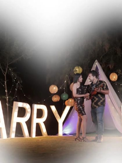 A magical pre-wedding proposal setup with "Marry Me" lights and a teepee tent. This creates an incredibly romantic and unforgettable scene for any couple.
