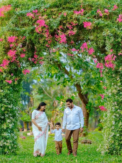 A simple walk together can create the most beautiful memories. We captured this family strolling hand in hand under a lush green arch, showcasing a natural, candid moment that tells a story of connection and togetherness.