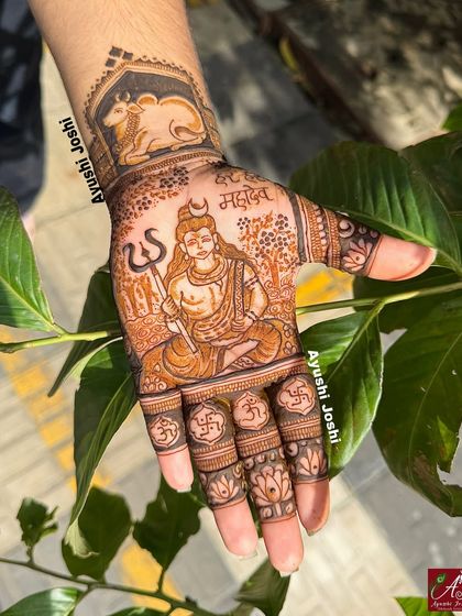 A clear, sunlit photo of the Mahadev mehendi, highlighting the intricate shading and the sacred Om and Swastik symbols on the fingers.