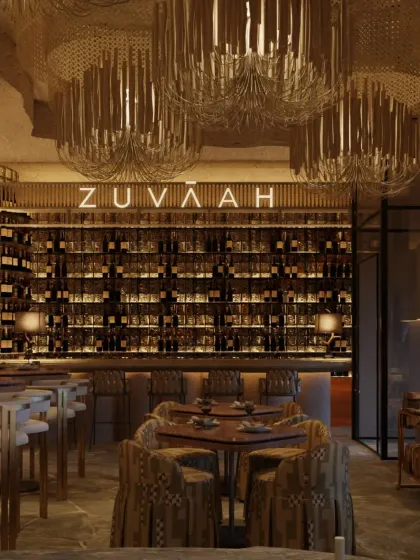 The ground-floor bar at Zuvaah feels like a hidden cavern. A beaded bar top, a backlit glass block wall, and a raw, textured bar front create a den-like ambiance where light dances and shadows whisper.